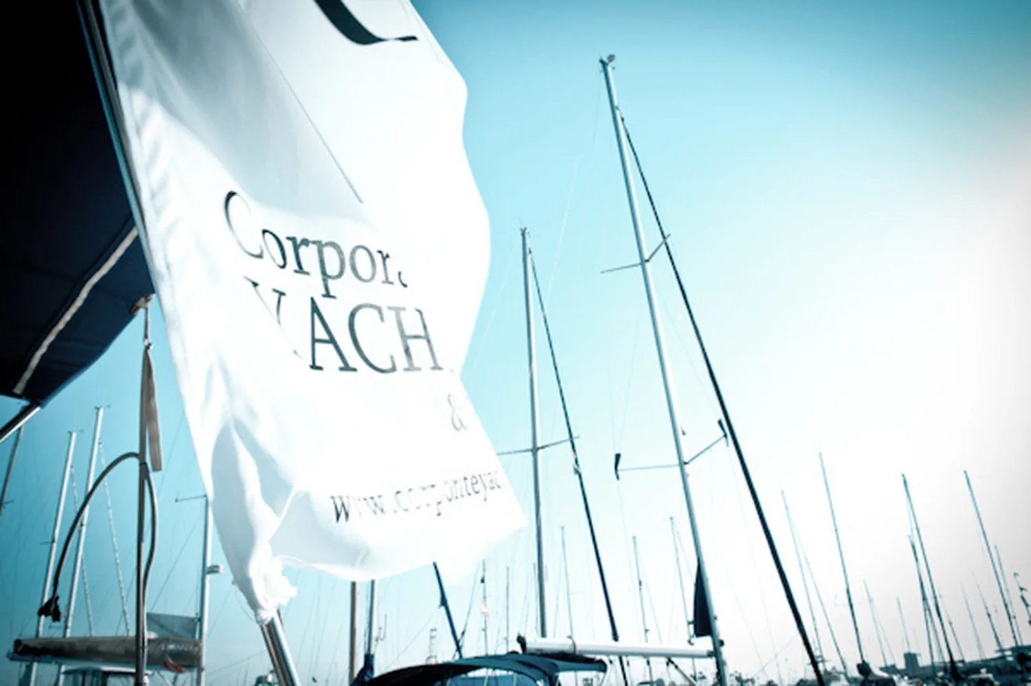 Gallardete de Corporate Yachting ondeando entre los mástiles del puerto deportivo.