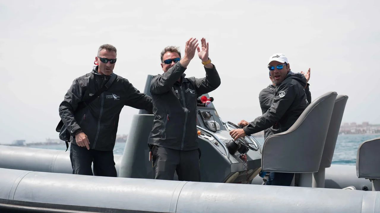 Tripulación celebrando con las manos alzadas a bordo de una zodiac de Corporate Yachting