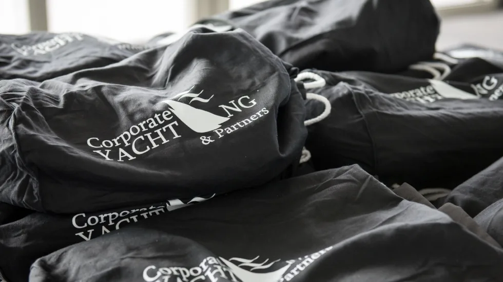 Bolsas de tela con el logotipo de Corporate Yachting & Partners apiladas