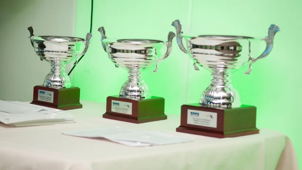 Tres trofeos de plata sobre una mesa como premio de la regata